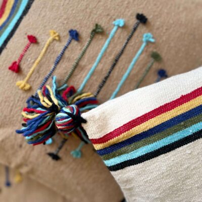 Coussin marocain berbère Tazra beige coin haut gauche sur plaid chocolat